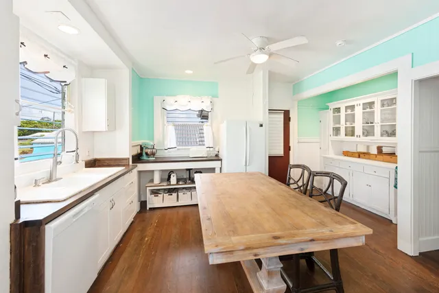 a large kitchen with kitchen island a stove a sink a dining table and chairs