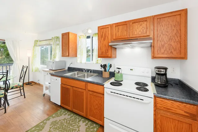 a kitchen with stainless steel appliances granite countertop sink stove top oven and cabinets