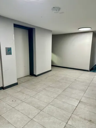 a view of a swimming pool with a bench and trees around