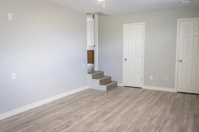 a view of a small space with wooden floor and a window