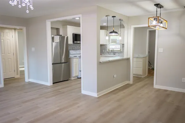 a view of a kitchen with refrigerator and wooden floor