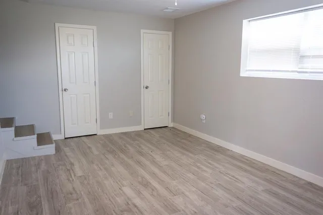 a view of an empty room with wooden floor