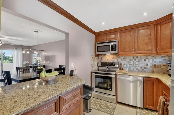 a kitchen with stainless steel appliances granite countertop a refrigerator and a sink