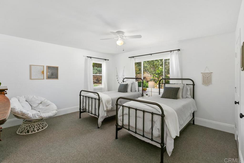 7880 Calle Dos Lagos Rancho Santa Fe, CA 92067 - Photo 22 of 44 a spacious bedroom with a bed and a chandelier