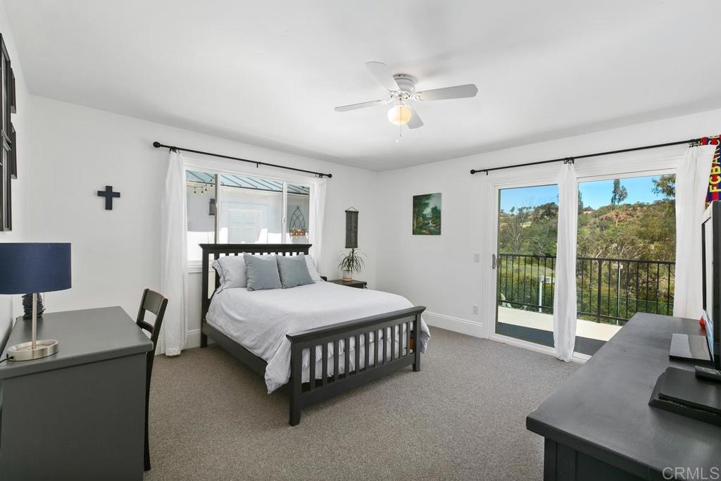 7880 Calle Dos Lagos Rancho Santa Fe, CA 92067 - Photo 23 of 44 a bedroom with a bed couch and a large window