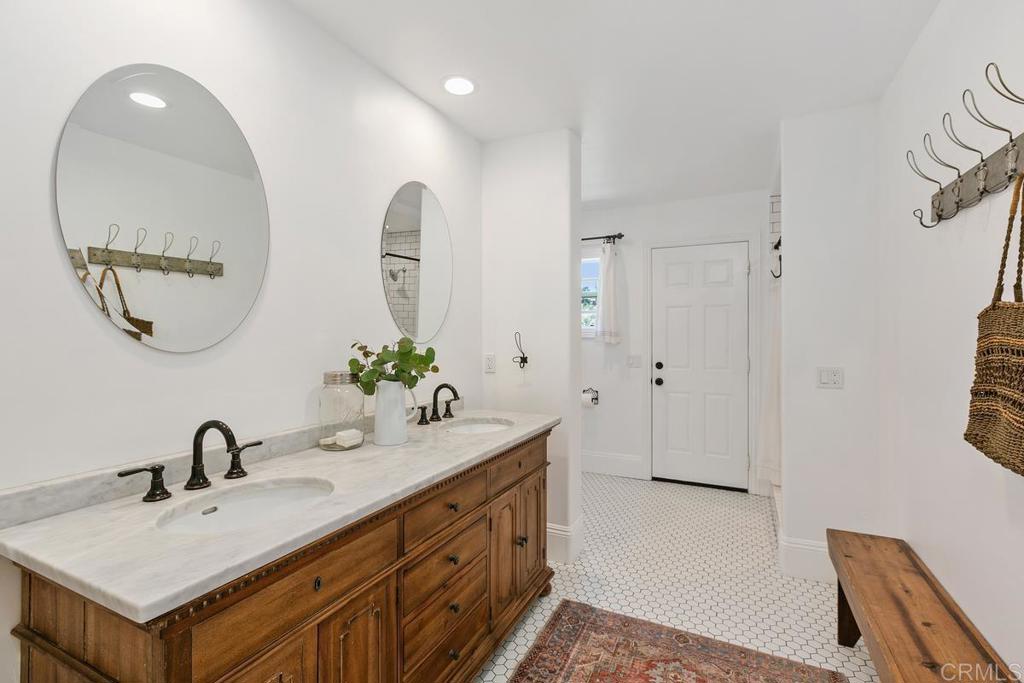 7880 Calle Dos Lagos Rancho Santa Fe, CA 92067 - Photo 26 of 44 a bathroom with a double vanity sink and a mirror