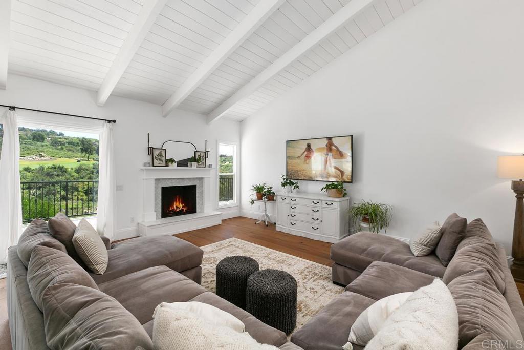 7880 Calle Dos Lagos Rancho Santa Fe, CA 92067 - Photo 6 of 44 a living room with furniture a fireplace and a flat screen tv