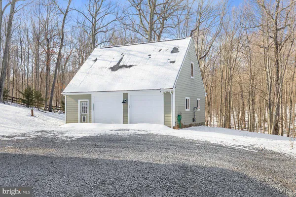 a front view of a house with a yard covered with snow