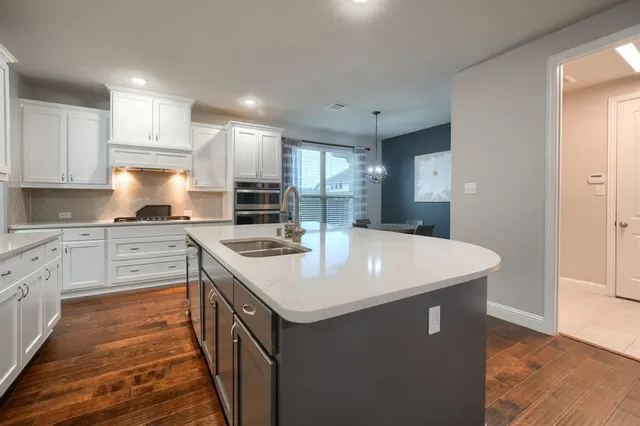 a kitchen with a sink stove and cabinets
