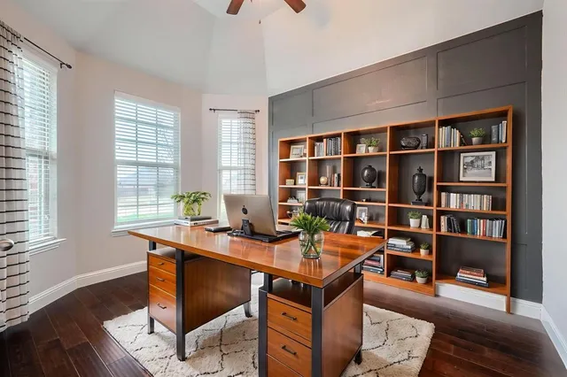 a view of a workspace with furniture and a bookshelf