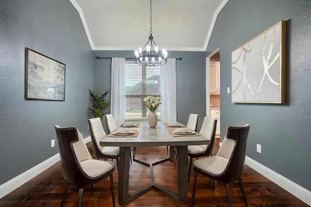 a view of a dining room with furniture a chandelier and wooden floor