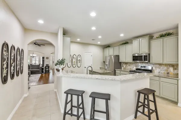 a kitchen with stainless steel appliances kitchen island granite countertop a sink and cabinets