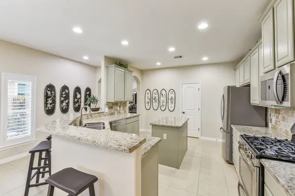 a kitchen with stainless steel appliances granite countertop a sink and a refrigerator