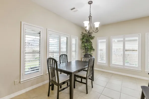 a dining room with furniture a chandelier and window