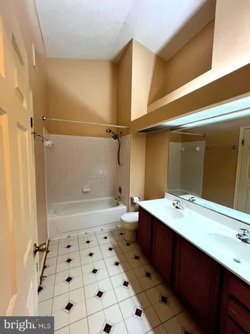 a bathroom with a sink a toilet a mirror and shower