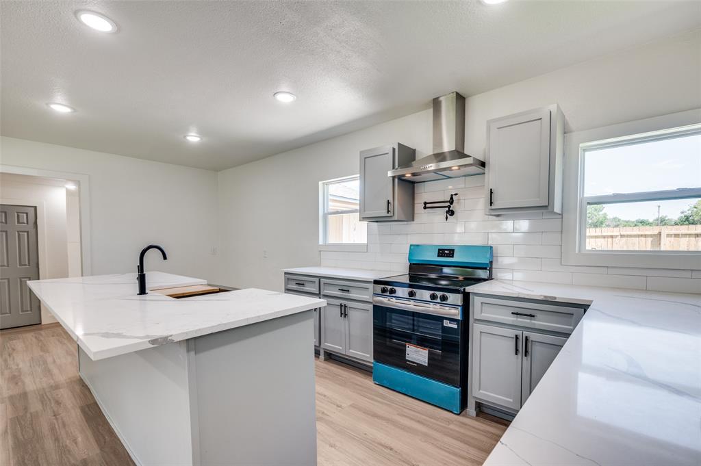 a kitchen with stainless steel appliances granite countertop a sink stove and cabinets