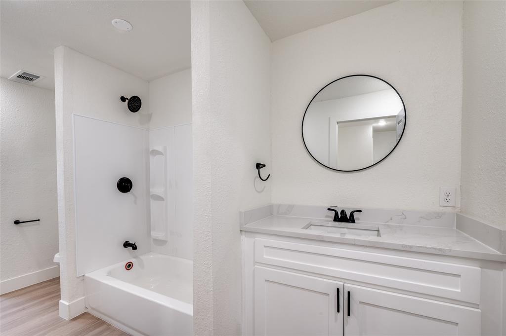 107 McArthur Lane Cleburne, TX 76031 - Photo 19 of 26 a bathroom with a tub a sink and a mirror