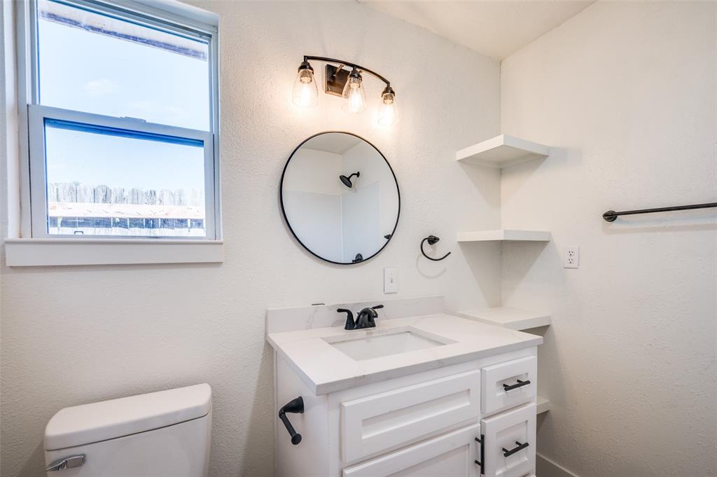 107 McArthur Lane Cleburne, TX 76031 - Photo 23 of 26 a bathroom with a sink a toilet and a mirror