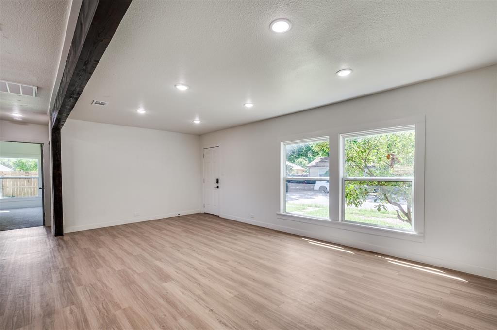 107 McArthur Lane Cleburne, TX 76031 - Photo 5 of 26 an empty room with wooden floor and windows
