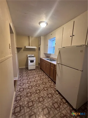 a kitchen with sink refrigerator and microwave