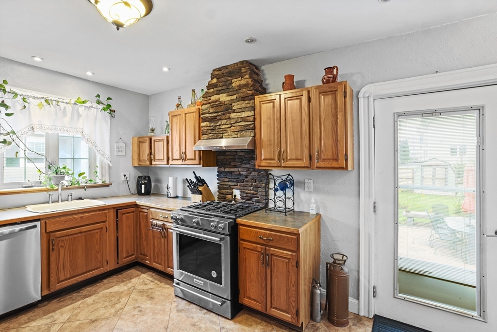 161 Foster Street Fall River, MA 02721 - Photo 10 of 20 a kitchen with stainless steel appliances granite countertop a sink a stove and a wooden floors