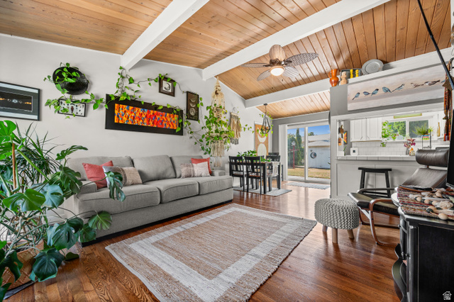 909 Rancho Boulevard Ogden, UT 84404 - Photo 4 of 27 Bright, open-concept living space featuring exposed wood-beam ceiling with skylights, hardwood flooring, and a neutral color palette