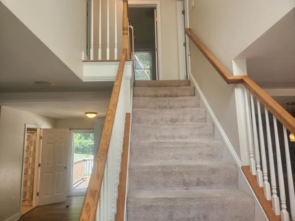 a view of staircase with lots of frames on wall and stairs