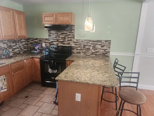 a kitchen with a sink a stove and a wooden cabinets