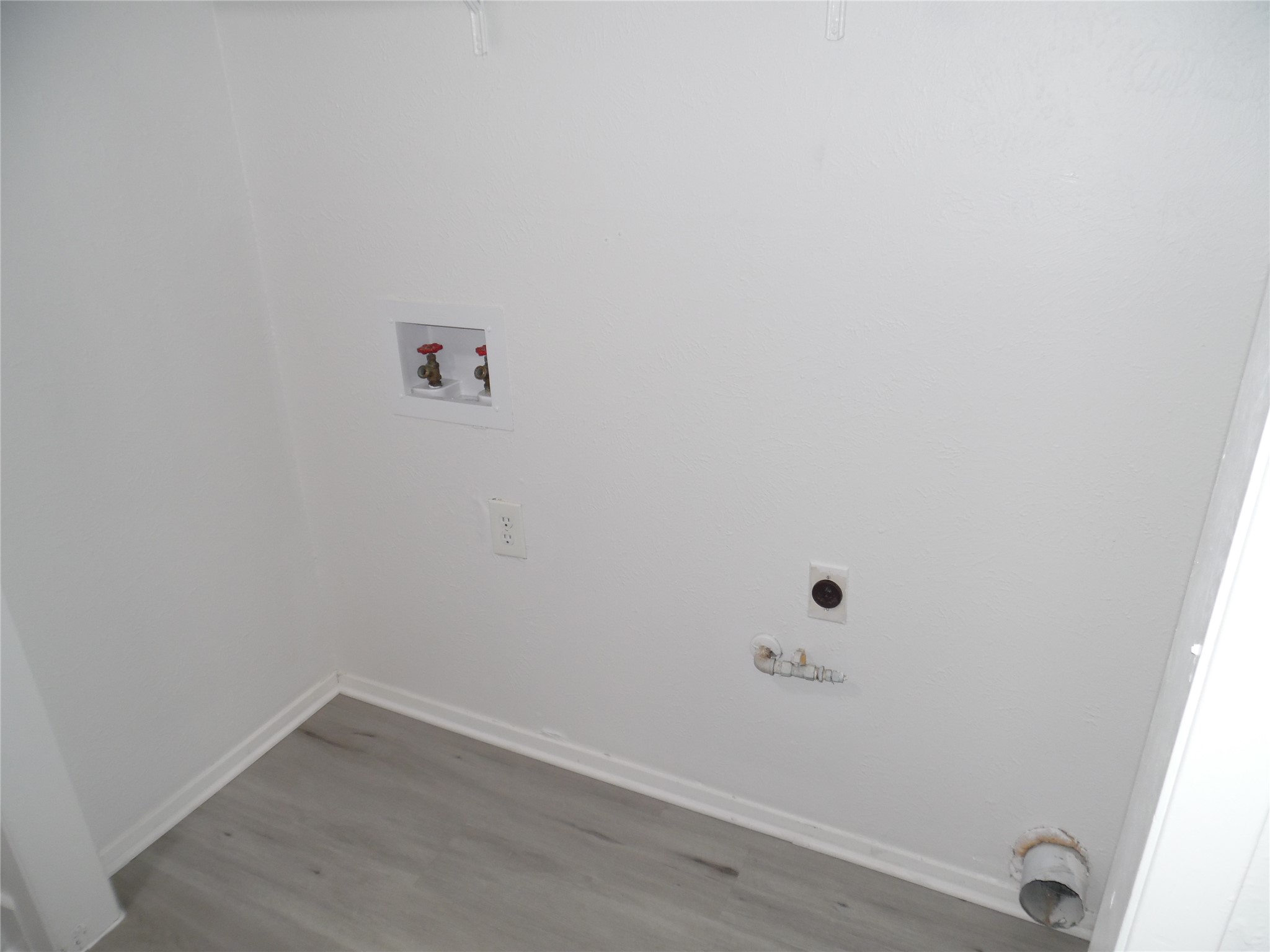7400 Dixie Drive, Unit B Austin, TX 78744 - Photo 11 of 15 Dedicated laundry space featuring wood-finish flooring, white walls, and bright white baseboards
