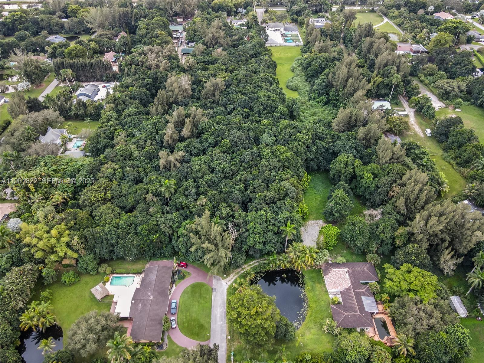 an aerial view of residential house with outdoor space and trees all around