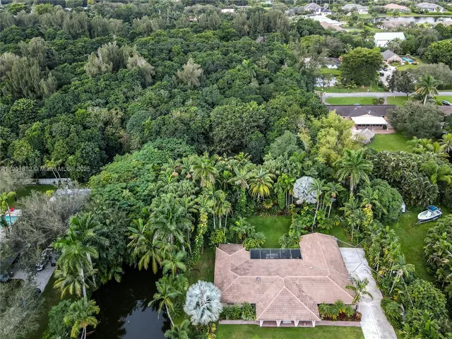 an aerial view of a house with yard outdoor seating and lake view