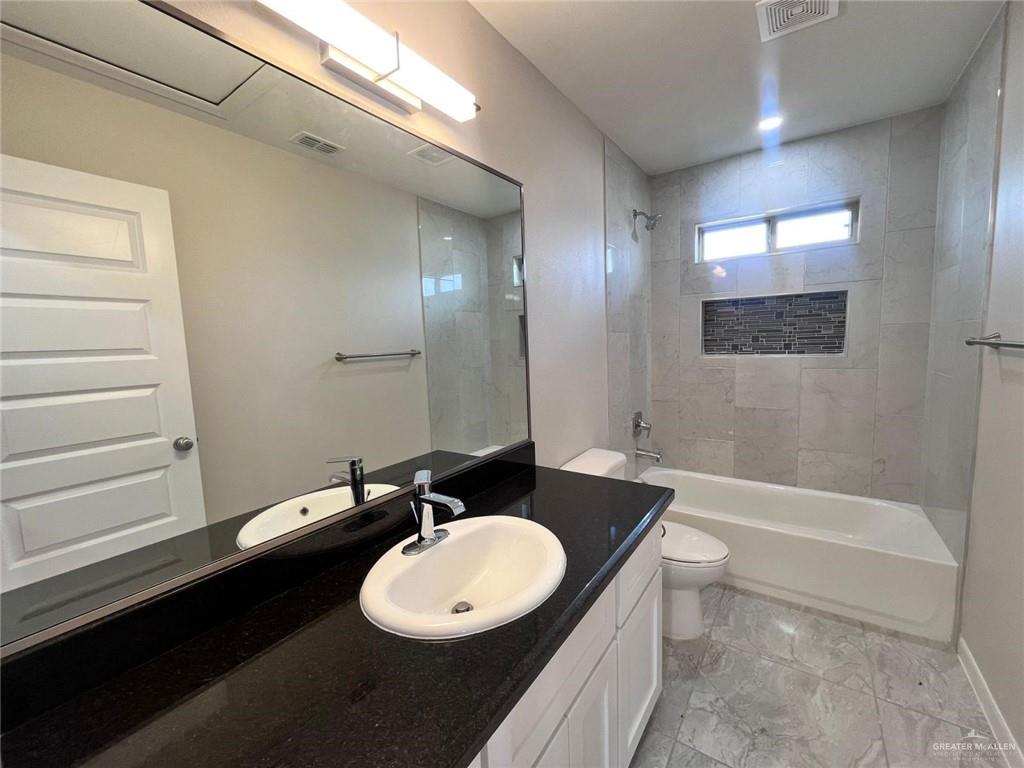 702 Palmer Road, Unit 1 Mission, TX 78573 - Photo 8 of 13 a bathroom with a double vanity sink and a mirror