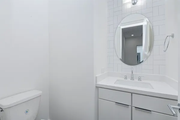 a bathroom with a sink a toilet and mirror