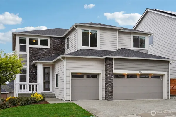 a front view of a house with a yard and garage