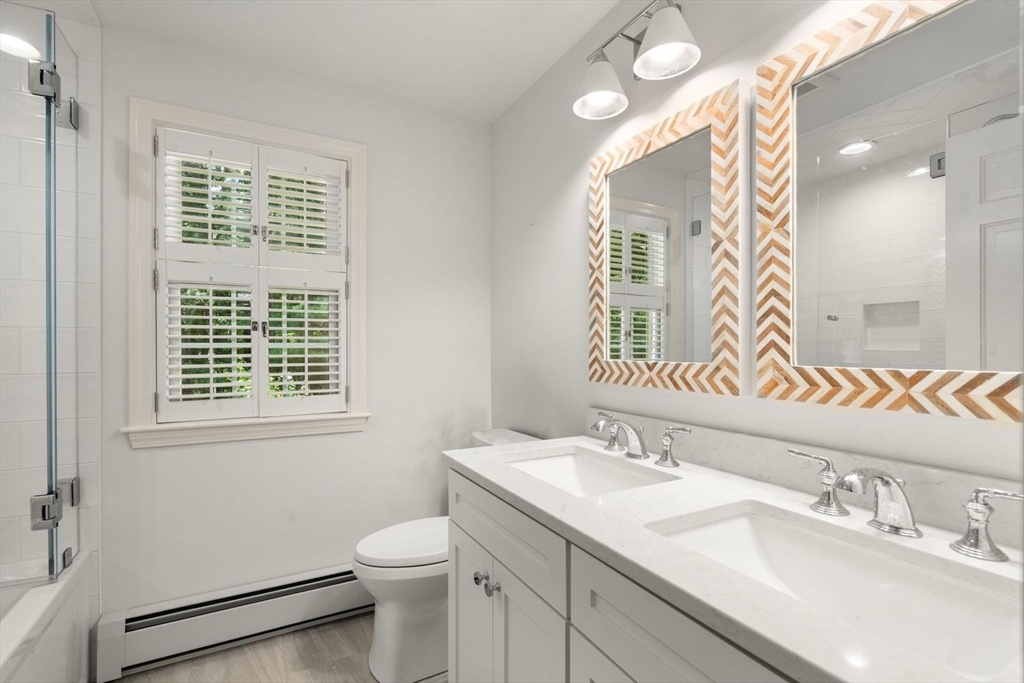 13 Wood Road Sherborn, MA 01770 - Photo 33 of 38 a bathroom with a granite countertop toilet a sink a mirror and a window
