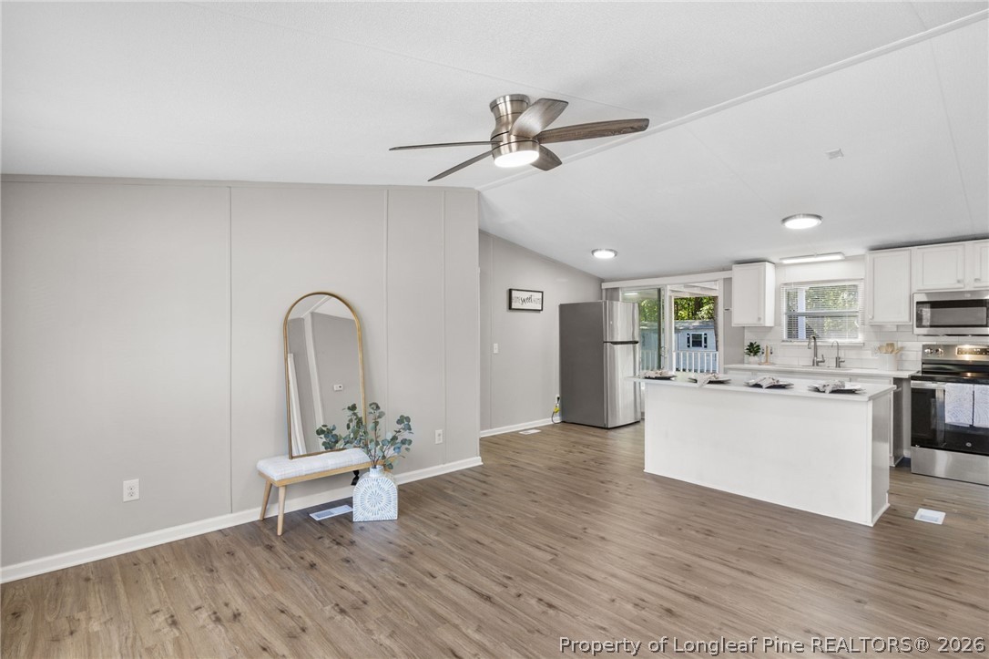 6568 Sandy Creek Road Stedman, NC 28391 - Photo 7 of 34 a living room with stainless steel appliances kitchen island furniture and wooden floor