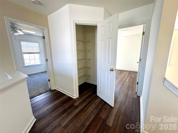 a view of a hallway with wooden floor and a living room