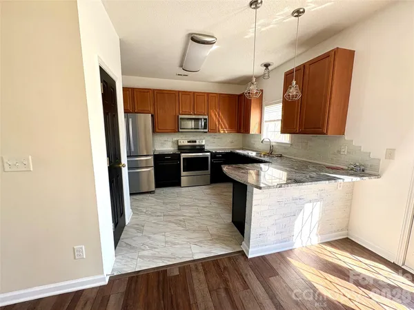 a kitchen with stainless steel appliances granite countertop a sink stove and refrigerator