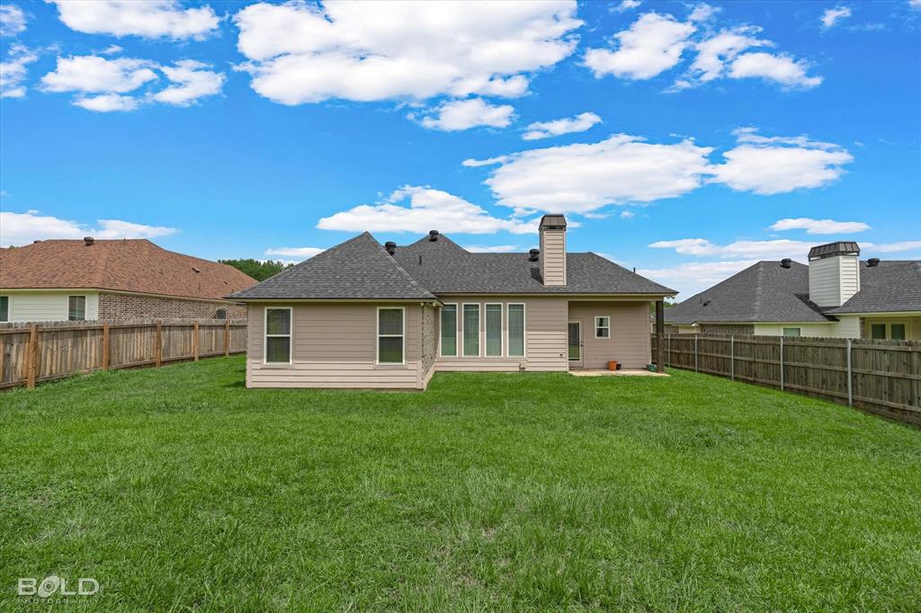 6896 Bethany Reed Circle Blanchard, LA 71107 - Photo 9 of 37 Expansive green lawn with a wood fence enclosure