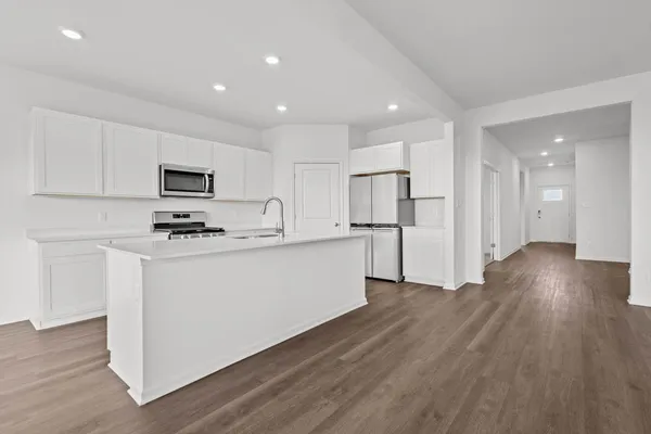 a kitchen with stainless steel appliances a sink stove refrigerator and cabinets