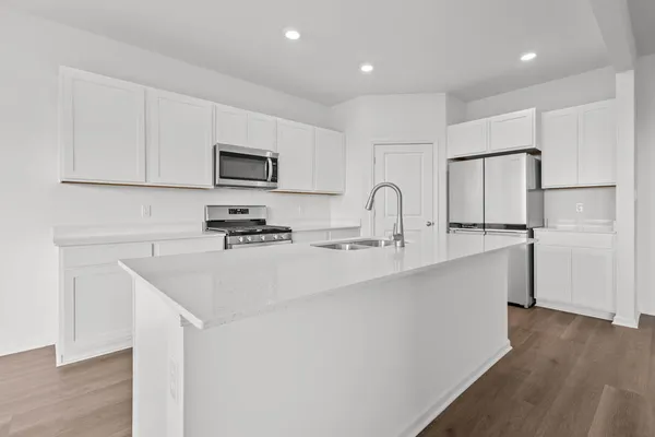 a kitchen with cabinets stainless steel appliances and a counter space