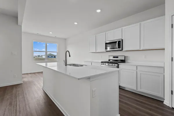 a kitchen with stainless steel appliances a stove microwave and white cabinets
