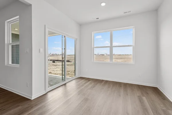 a view of a kitchen with wooden floor and a window