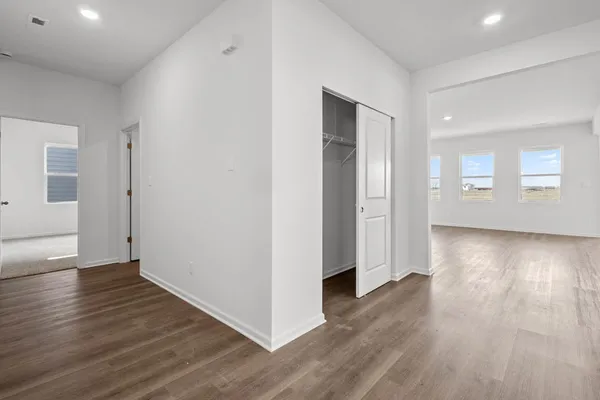 an empty room with wooden floor & windows and bathroom