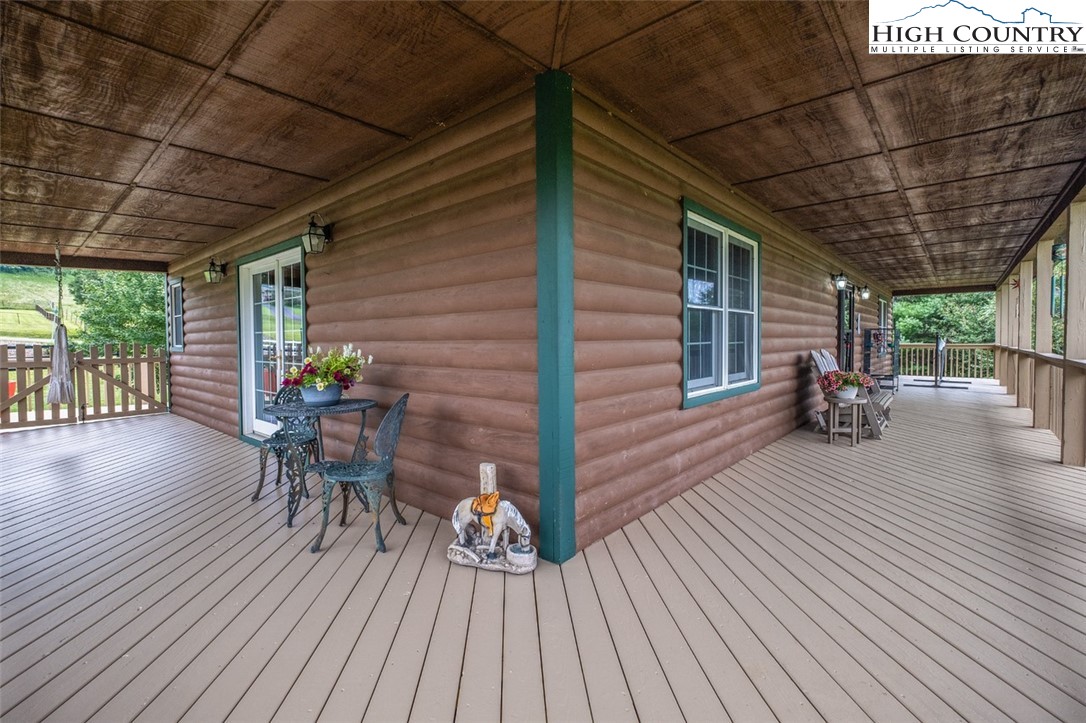 1453 Big Flatts Church Road Fleetwood, NC 28626 - Photo 12 of 50 a view of a patio with table and chairs a barbeque with wooden floor and roof