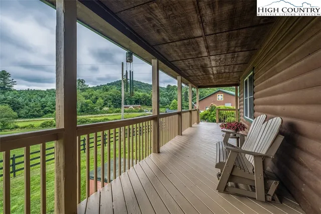 a balcony with wooden floor table and chairs