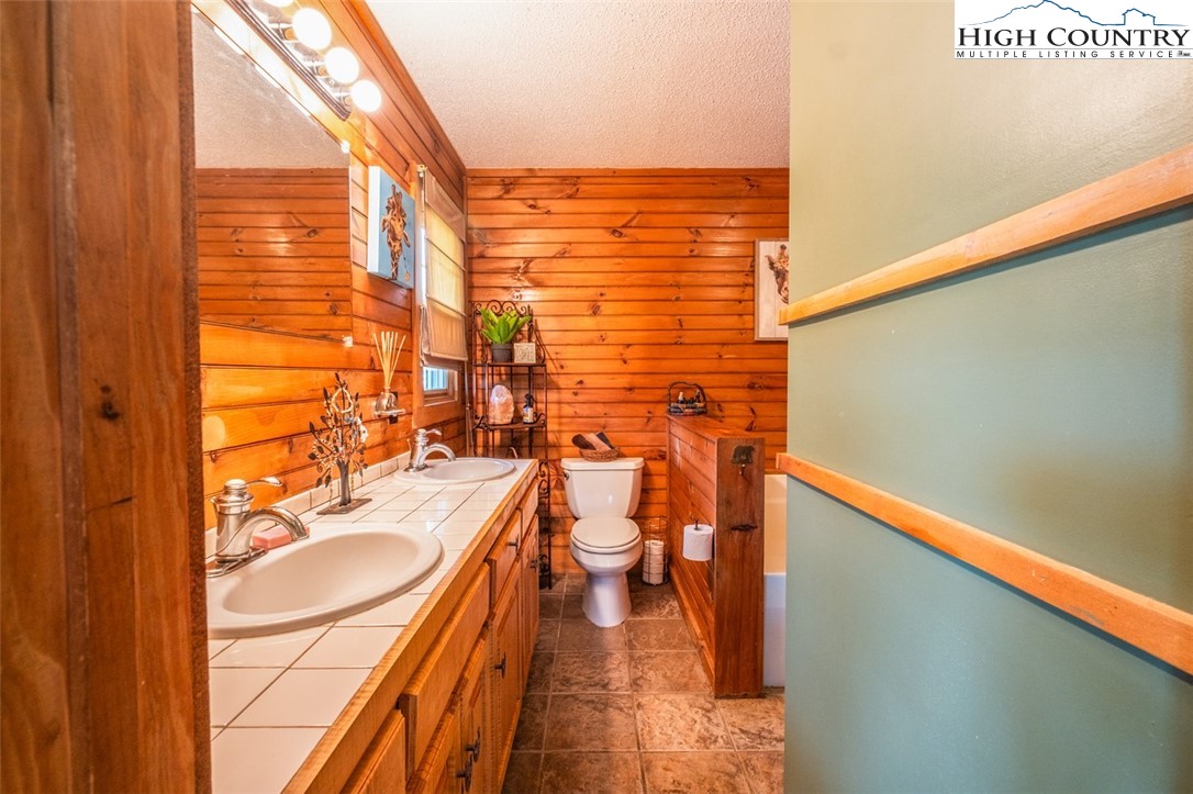 1453 Big Flatts Church Road Fleetwood, NC 28626 - Photo 26 of 50 a bathroom with a sink a toilet and shower curtain
