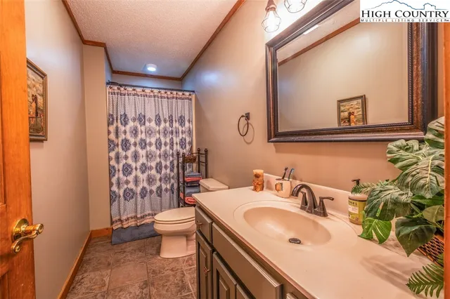 a kitchen with granite countertop a stove a sink dishwasher and white cabinets with wooden floor