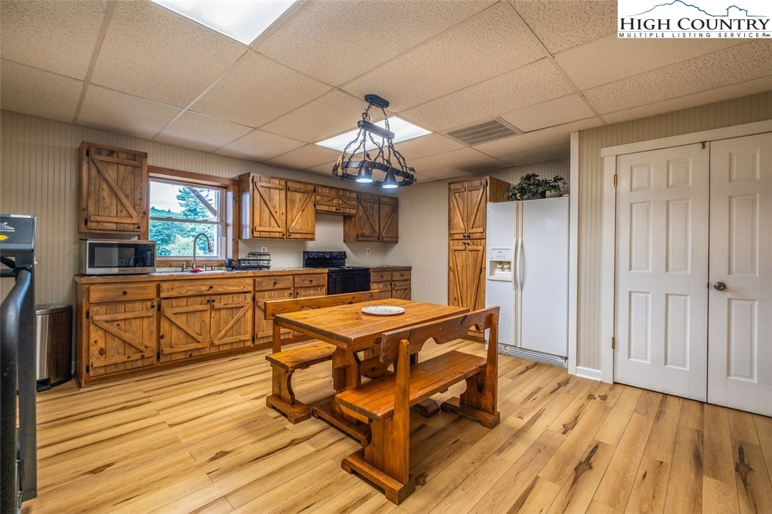 1453 Big Flatts Church Road Fleetwood, NC 28626 - Photo 33 of 50 a kitchen with granite countertop a stove a sink dishwasher and white cabinets with wooden floor
