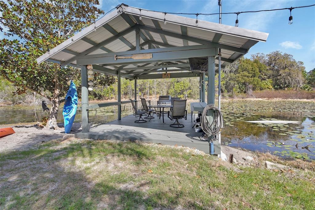1403 Blackwelder Road De Leon Springs, FL 32130 - Photo 15 of 93 a view of a patio with table and chairs under an umbrella